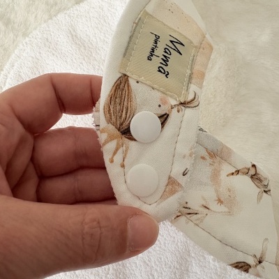 Fralda ou babete branco com padrão de coelhos e fechos de pressão