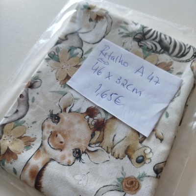 Tecido com padrão de animais e flores, embalado com etiqueta manuscrita