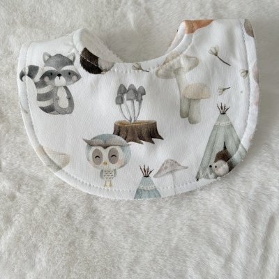 Babete redondo branco com padrão de bosque, coruja, guaxinim, cogumelos e cabana tipi