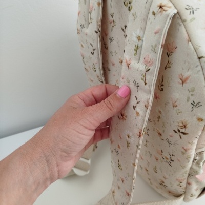 Mochila creme com padrão de flores e alças acolchoadas ajustáveis