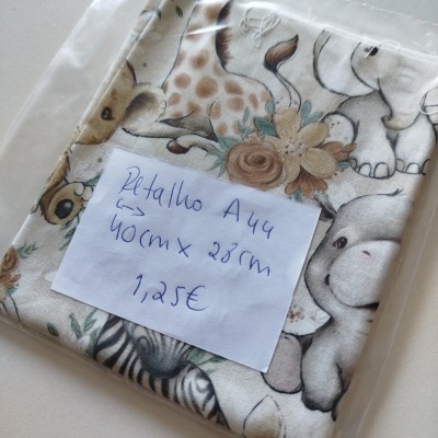 Tecido com padrão de animais e etiqueta com medidas e preço