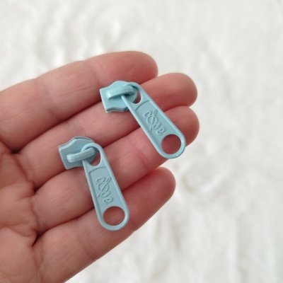 Puxadores de fecho éclair azuis em mão}