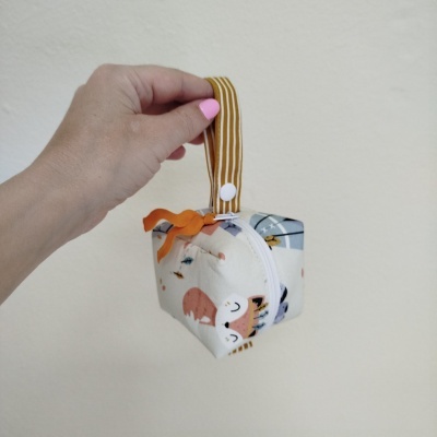 Bolsa pequena de tecido com padrão de animais e alça castanha com riscas