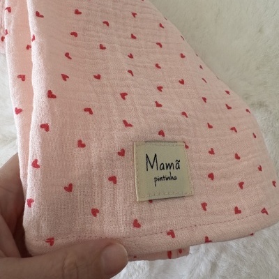 Toalha cor-de-rosa com corações vermelhos e etiqueta mamã pintinha