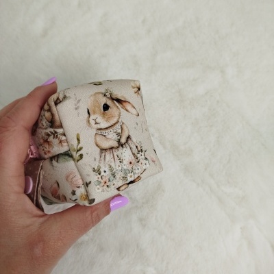 Laços de tecido com padrão de coelhos e flores nas mãos