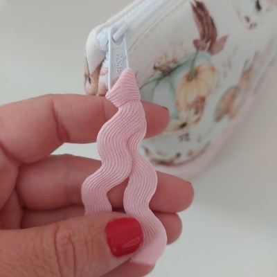 Fecho de zíper branco com puxador rosa e bolsa floral