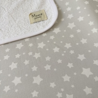 Toalha branca de algodão com etiqueta e fundo cinza com estrelas brancas