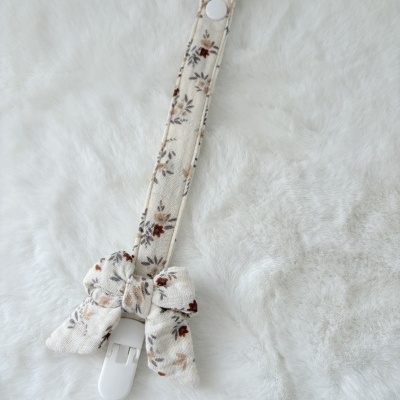 Fita para chupeta em tecido bege com padrão floral e clip branco
