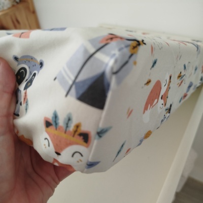 Capa de tecido infantil com animais e tenda colorida.