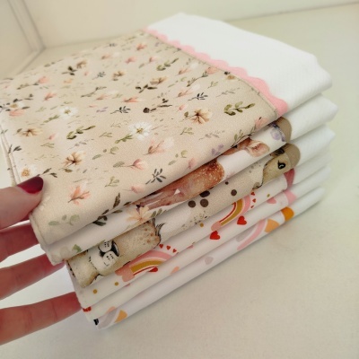 Panos brancos com cantos estampados variados empilhados