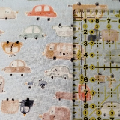 tecido azul claro com padrão de carros em tons pastel e régua amarela