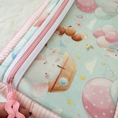 Mochila infantil com padrão colorido de animais e balões em tecido, com fecho rosa