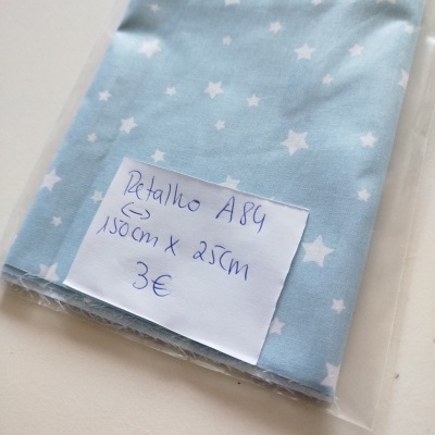 Tecido azul claro com estrelas brancas embalado com etiqueta manuscrita