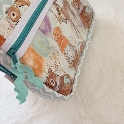 Bolsa ou estojo com fecho azul turquesa e estampa de animais em tecido