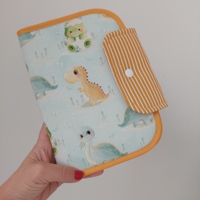 Carteira azul clara com estampa de dinossauros e fecho de riscas laranja