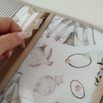 Carteira ou organizador beige com padrão infantil e fecho de correr