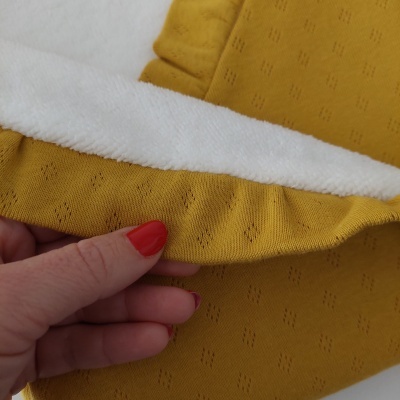Tecido amarelo mostarda com interior branco felpudo e padrão delicado