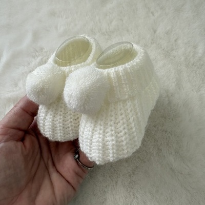 Botins de bebé em tricô branco com pompom