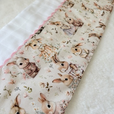 Tecido acolchoado com padrão de coelhos e flores e acabamento rosa