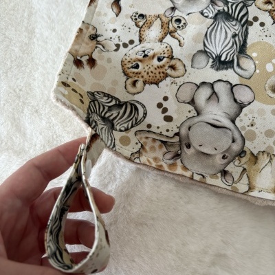 Tecido com estampa de animais selvagens em tons neutros e fundo branco texturizado