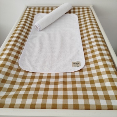 Colchão de bebé xadrez com toalha branca e pano felpudo
