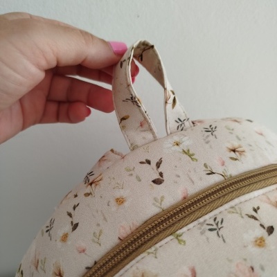 Mochila bege com flores e fecho castanho