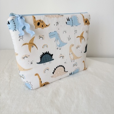 Bolsa de tecido com padrão de dinossauros coloridos e fecho azul claro