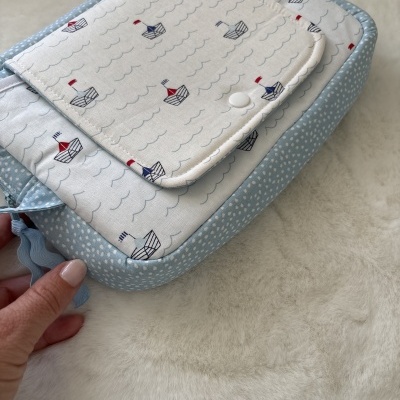 Bolsa de tecido com padrão de barcos e borda azul com pontos brancos