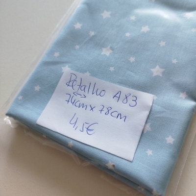 Retalho tecido azul claro com estrelas brancas e etiqueta manuscrita dentro de plástico