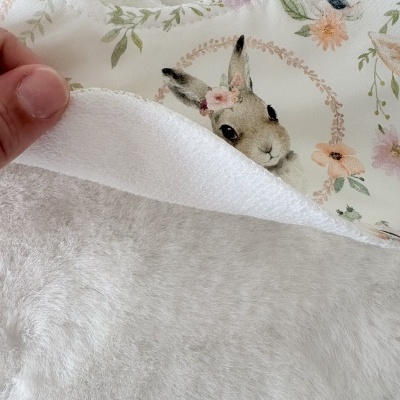 Babete branco com estampa de coelho e flores, verso em tecido de toalha branco.