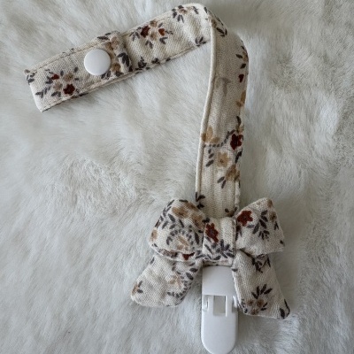 Prendedor de chupeta com fita floral e botão branco