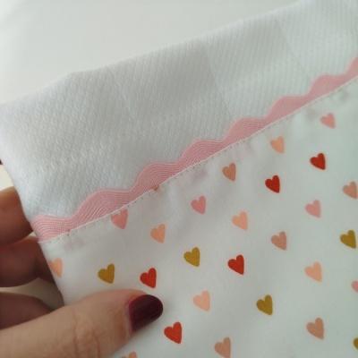 tecido com padrão de corações e borda rosa ondulada