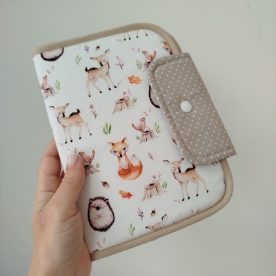 Carteira com padrão de animais da floresta em fundo branco e fecho bege com bolinhas brancas