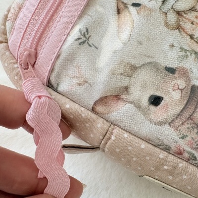 Estojo cor-de-rosa com estampa de coelhinhos e flores e zíper cor-de-rosa