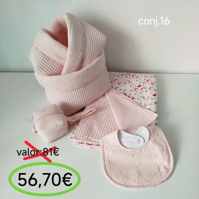 Conjunto de banho bebé cor de rosa com toalha, babete e acessórios numa superfície branca.