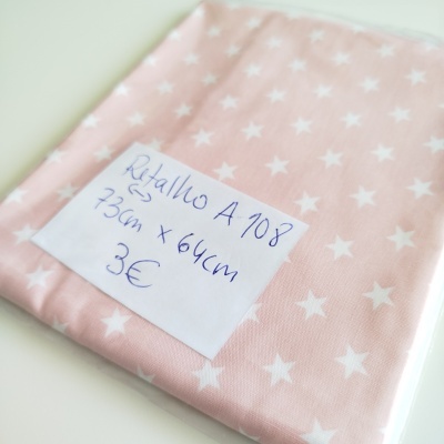Retalho de tecido rosa com estrelas brancas e etiqueta manuscrita