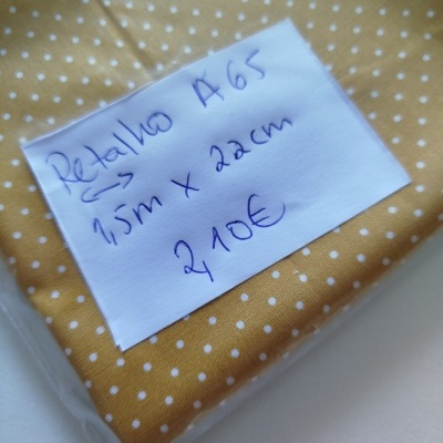 tecido amarelo com pontos brancos e etiqueta com preço