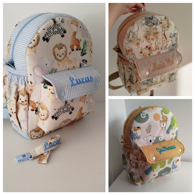 Três mochilas infantis com estampas de animais e nomes bordados, cada uma de cor e padrão diferentes.