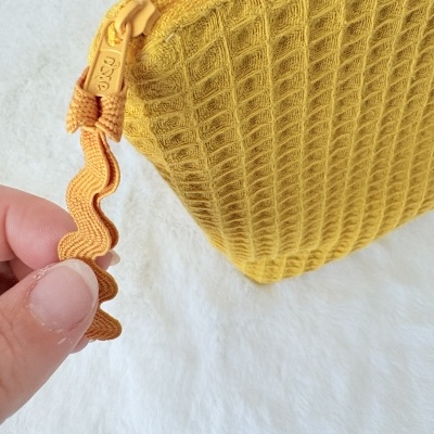 Bolsa amarela texturizada com fecho de correr amarelo e fita puxadora