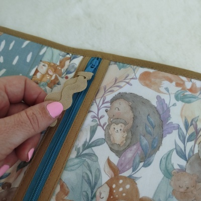 Capa de tecido com padrão de animais da floresta e fecho de correr azul