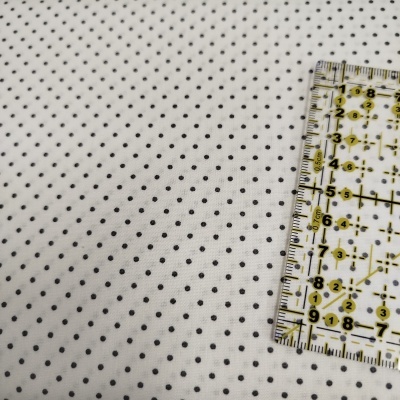 Tecido branco com pontos pretos e régua de medição transparente