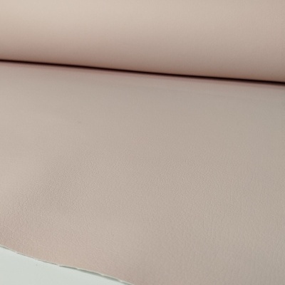 Rolo de tecido cor de rosa com textura fina sobre superfície branca