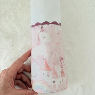 Fralda branca com capa de tecido rosa com unicórnios e castelo