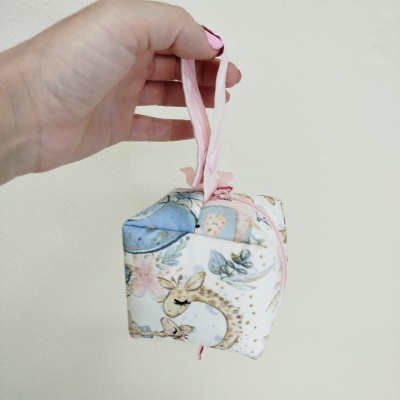 Bolsa pequena em tecido com padrão de girafas e elementos em tons pastel