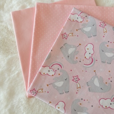 Três tecidos rosa com diferentes padrões sobre superfície branca felpuda