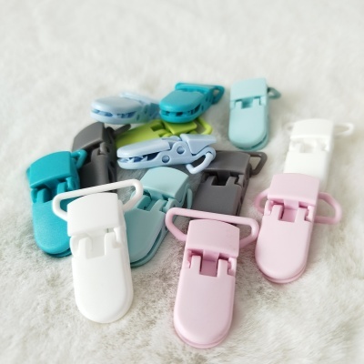 Prendedores de plástico coloridos sobre superfície macia branca