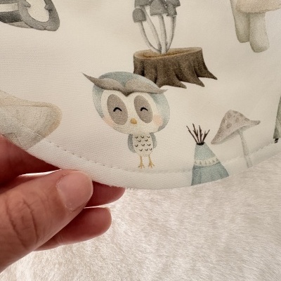 Tecido branco com estampado de coruja e elementos da floresta em tons pastel