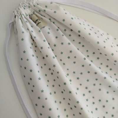 Saco de pano branco com estrelas verdes e cordão de fecho branco