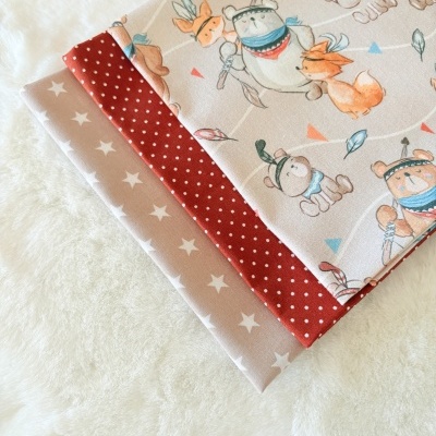 Três panos de tecido com padrões variados sobre superfície branca felpuda