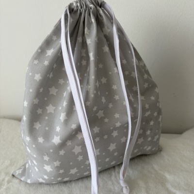 Mochila saco cinza com estrelas brancas e cordões brancos